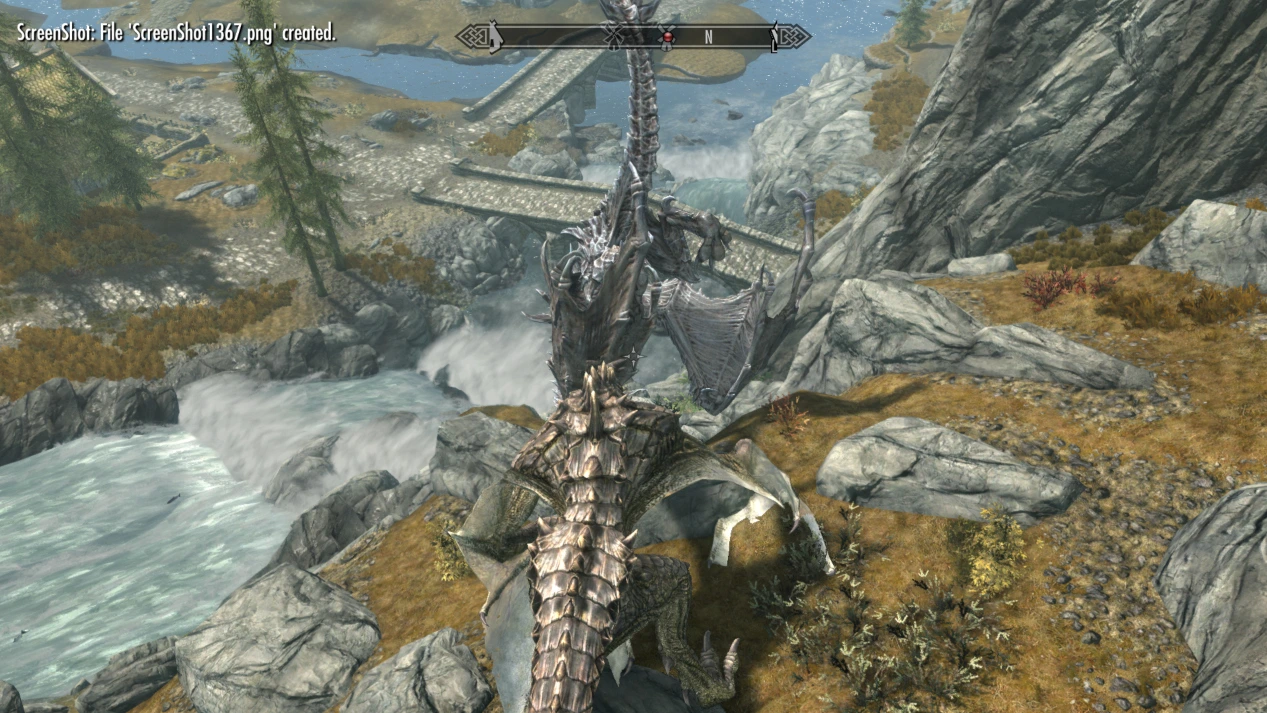 The player - a dragon - pushes the evil dragon, Alduin, into the river at the bottom of the mountain